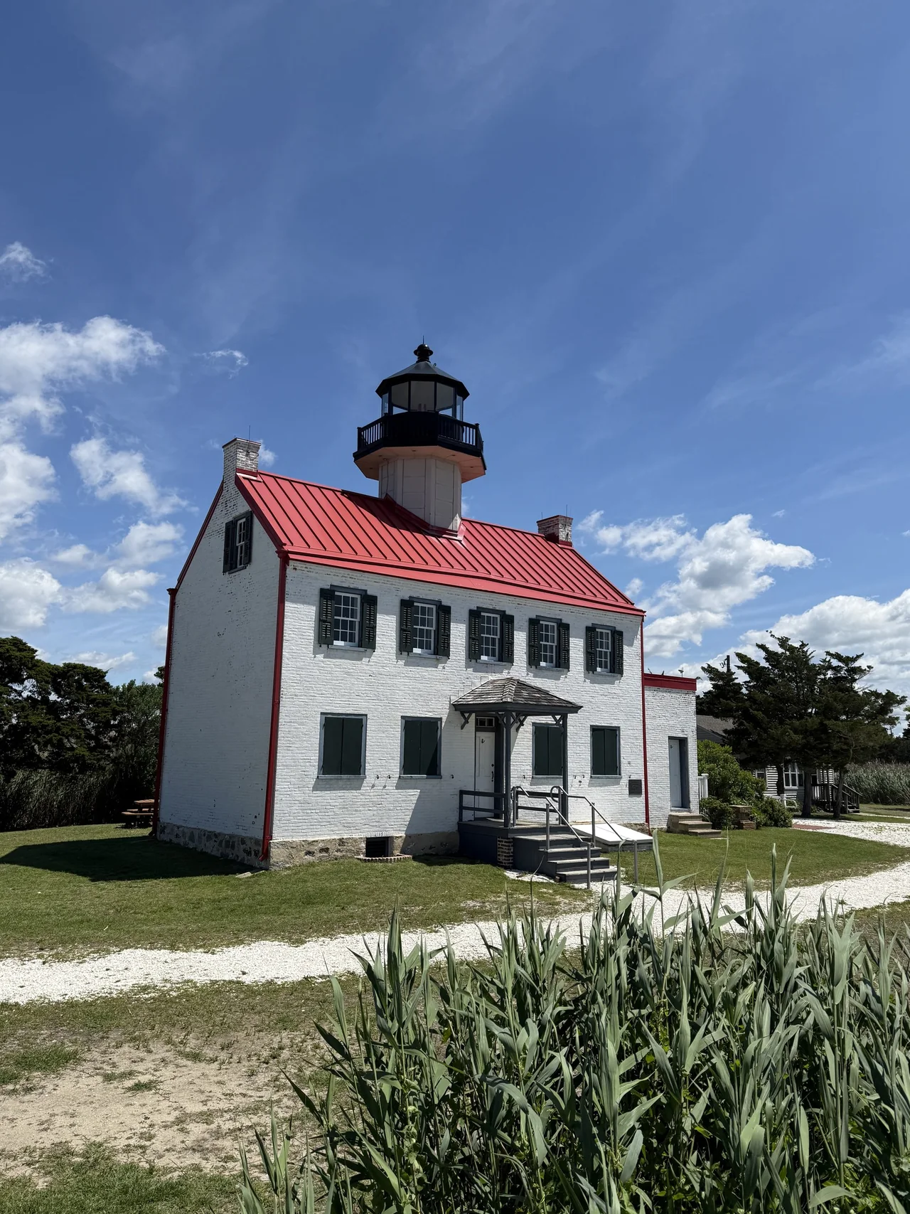 White East Point Lighthouse with its red roof against a blue New Jersey sky